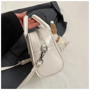 White soft leather bowling handbag casual crossbody shoulder bag for women commuter daily use.