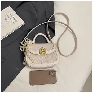 Elegante bolso de mano tejido con asa, cierre metálico y elegante colgante de perlas.