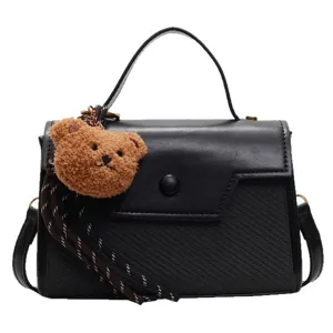 Fashion black top-handle small square bag with cute brown teddy bear plush pendant charm.