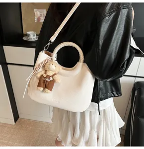 Modische Damen Handtasche mit rundem Griff und Bärenanhänger, elegante Umhängetasche aus Leder.
