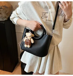Nahaufnahme Detailansicht einer schwarzen PU Leder Handtasche mit Bären Anhänger