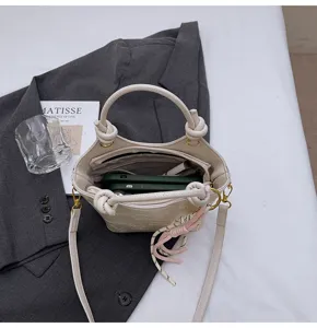 Detail view of a retro casual PU leather bucket bag in elegant beige with knotted handle.