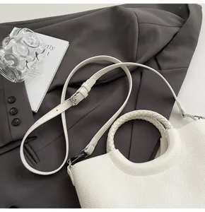Elegante weiße Handtasche aus Leder mit geflochtenem Rundgriff und verstellbarem Umhängegurt.