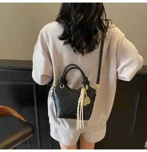 Chic black bucket bag with embossed animal patterns, chic pendant and comfortable strap.