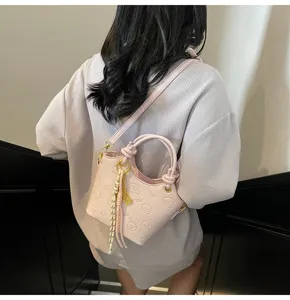 Detail view of a chic pink leather bucket bag, stylish crossbody design for women.