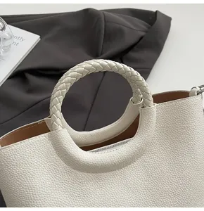 Weißes Leder Handtaschen Detail, elegantes geflochtenes rundes Griffdesign für Damen Stil.