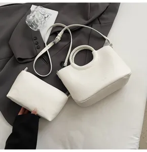 Schicke weiße Handtasche mit rundem Henkel und passender Tasche sowie stylischem Umhängegurt.