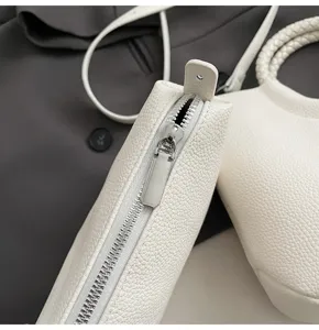 Nahaufnahme der Details von weißem strukturiertem Lederhandtaschen-Reißverschluss.