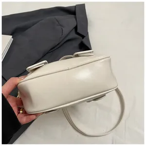 Soft white leather shoulder bag detail showing bottom structure and fine strap design.