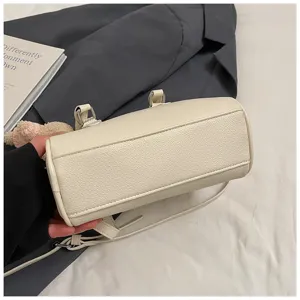 White soft leather bowling bag for women, stylish minimalist handbag with shoulder strap.