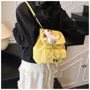 Vue détaillée du mini sac à dos matelassé jaune élégant avec chaîne et jolie poupée.