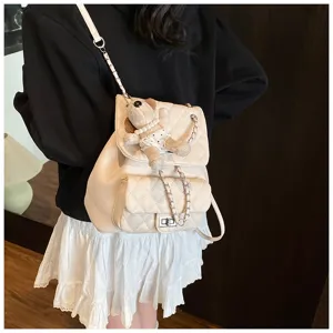 Sac à dos matelassé beige chic avec bandoulière chaîne et joli pendentif ours pour femme.