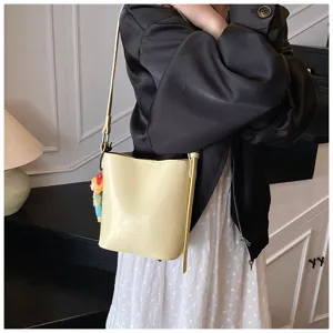Stylish yellow leather bucket bag for women, chic casual shoulder crossbody handbag.