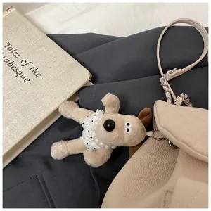 Gros plan sur un mini sac à dos matelassé chic avec pendentif chien en peluche et chaîne.