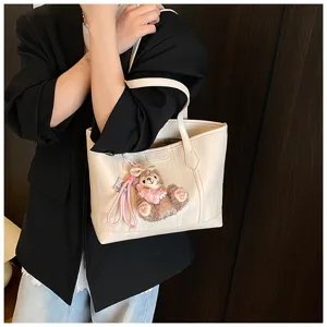 Elegante weiche Ledertragetasche für Damen mit süßem Plüschanhänger, ideal für Pendler.
