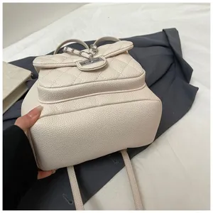 Mini sac à dos matelassé à chaîne pour femmes, sac à double épaule en cuir beige tendance.