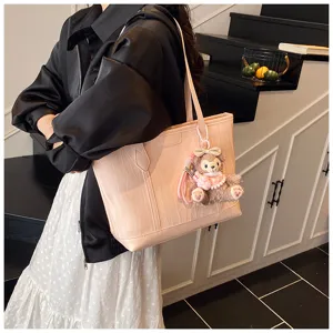 Rosa weiche Leder-Shopper Umhängetasche mit Prägung und süßem Plüschbären-Anhänger.