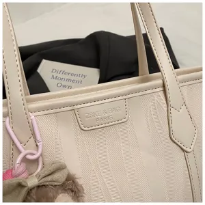 Nahaufnahme Detail der beigen Ledertasche, strukturierte Muster, stilvolles Schultertaschen-Zubehör.