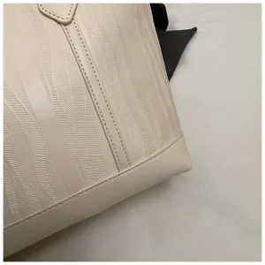 Nahaufnahme eines schicken beige Kunstleder Shoppers mit elegantem strukturiertem Muster.
