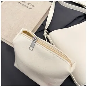 Minimalist white leather sub-mother bag detail, featuring smooth zipper and soft texture.