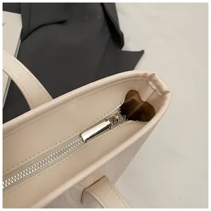 Nahaufnahme des Reißverschlusses und der Textur der Beigefarbenen Damen-Handtasche.