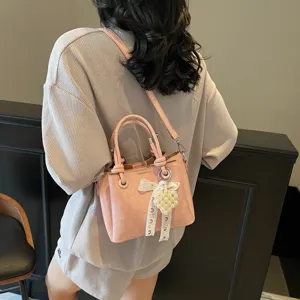 Pink PU leather bucket bag with pearl pendant and lace bow, casual chic crossbody bag.