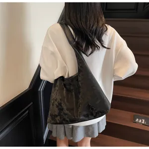 Vue détaillée d'un sac porté épaule noir vintage vieilli présenté dans un décor intérieur.