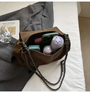 Braune Wildleder Kette Schultertasche Detail zeigt grosse Kapazitaet und Metallgurt.