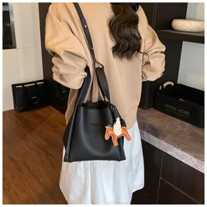 Detailed view of the elegant black bucket bag showcasing its unique design and winged charm.