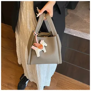 Elegant grey leather bucket bag with cute flying horse charm, perfect autumn handbag.