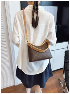 Detail view of brown monogram shoulder underarm bag with leather trim and stylish crescent shape.