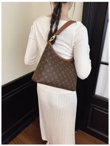 Detailed view of women's brown monogram shoulder bag, stylish hobo design with comfortable strap.