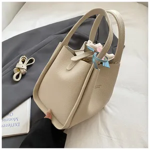 Chic beige bucket bag for women, stylish leather tote handbag with double handles, elegant detail.