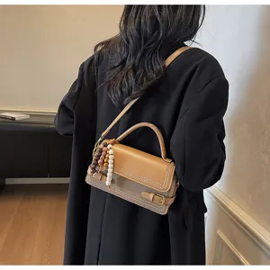 Stylish two-tone shoulder bag for women, chic crossbody purse with bead charm and top handle.