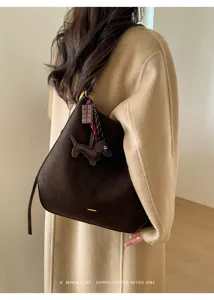 Nahaufnahme der dunkelbraunen Wildleder-Tasche mit Hundemotiv für elegante Damen im Alltag.