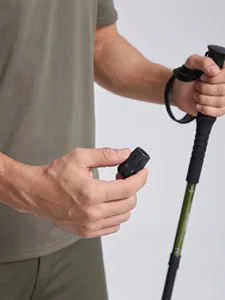 Close-up of trekking pole locking mechanism and green shaft detail for outdoor hiking.