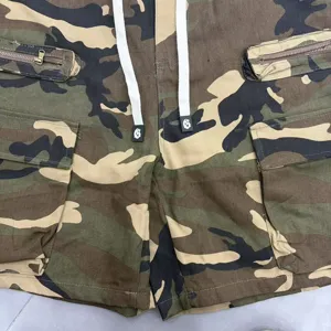 Camo cargo shorts close-up, featuring white drawstrings, utility pockets, and streetwear style.