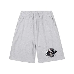 Vue détaillée de short streetwear gris avec graphique de casque de crâne et cordons.