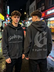 Close-up detail of the washed black streetwear hoodie featuring rhinestone lettering and gothic G logo.