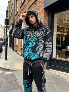 Detailed view of trendy streetwear hoodie and pants set featuring bold graffiti prints.