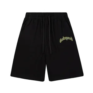 Gros plan détaillé de short de loisir noir avec une impression de texte streetwear incurvée.