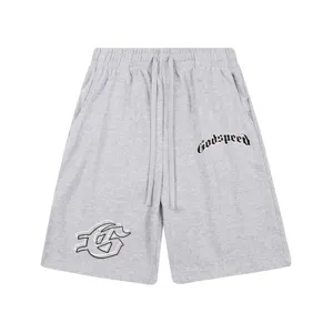 Short gris avec cordon de serrage, texte gothique et détail d'emblème streetwear.