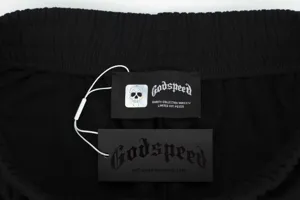 Gros plan sur la taille de shorts noirs décontractés avec étiquettes et logo crâne gothique.