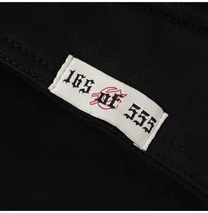 Close-up of streetwear denim shorts detail featuring custom numbered embroidery label.