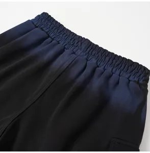 Close-up detail of the elastic waistband and gradient fabric on casual streetwear shorts.