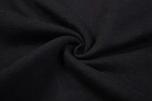 Détail de tissu en coton noir montrant une texture fine et un drapé spiralé doux.