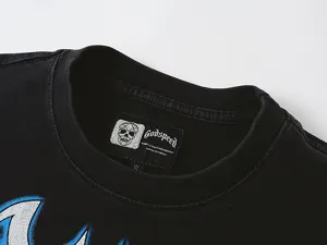 Detailed view of the black washed streetwear t-shirt collar, featuring brand label and skull graphics.