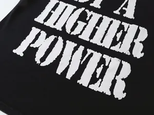 Close-up detail shot of the vintage washed black t-shirt with distressed white letter print.