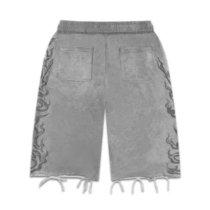 Shorts de streetwear gris délavé avec imprimé flamme tribale et ourlet brut effiloché.
