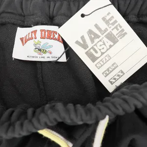 Détail de short streetwear décontracté noir avec cordon de serrage et étiquette de marque.